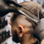 Client doing hair cut at a barber shop salon
