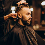 Young man at barbershop trimming hair